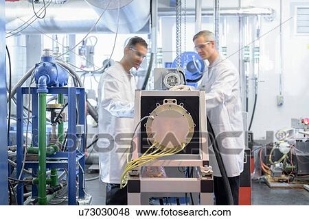 Stock Photo - Scientists testing lithium car battery with electric motor car in battery research facility. Fotosearch