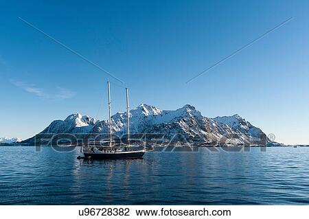 Stock Image - Ship sailing in front of snow capped mountains, Svolvaer, Lofoten Islands, Norway. Fotosearch