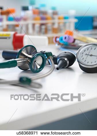 Stock Image - Stethoscope, auriscope, blood pressure gauge on desk. Fotosearch