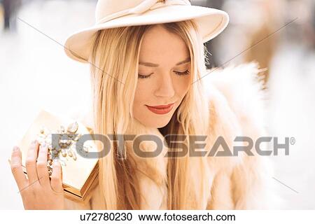 Stylish young woman holding gold jewelry box, Covent Garden, London, UK View Large Photo Image Stock Image - Stylish young woman holding gold jewelry box, Covent Garden, London, UK. Fotosearch