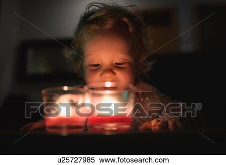 Surface level view of preschool girl looking down at burning candles View Large Photo Image Stock Photography - Surface level view of preschool girl looking down at burning candles. Fotosearch