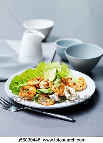 Stock Photo - Tandoori prawns and chargrilled calamari with lime slice and lettuce. Fotosearch