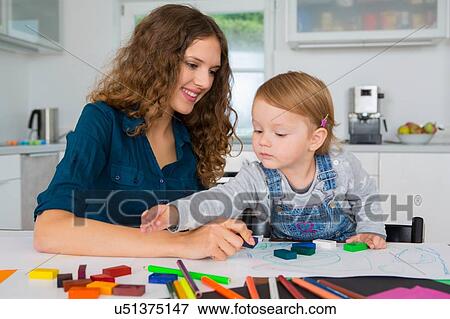 Teenage girl and female toddler drawing at kitchen table View Large Photo Image Stock Photo - Teenage girl and female toddler drawing at kitchen table. Fotosearch