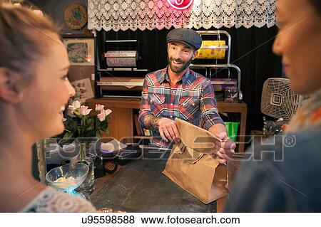 Two young female customers buying from vintage shop View Large Photo Image Stock Photo - Two young female customers buying from vintage shop. Fotosearch
