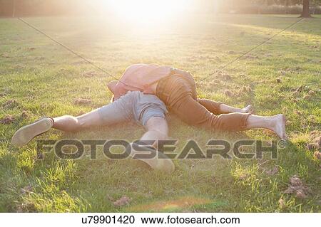 Two young men play fighting on park grass View Large Photo Image Stock Image - Two young men play fighting on park grass. Fotosearch