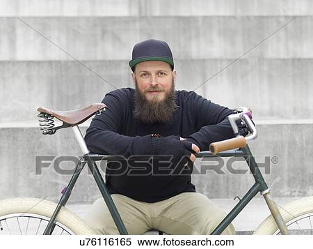 Stock Photography - Urban cyclist on steps leaning on bicycle. Fotosearch