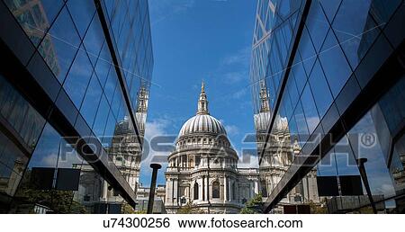 Stock Photograph - View of St Pauls Cathedral between glass fronted office buildings, London, UK. Fotosearch