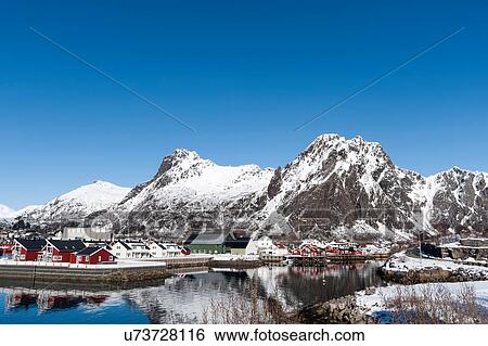 Stock Photograph - Waterfront houses and snow capped mountain, Svolvaer, Lofoten Islands, Norway. Fotosearch