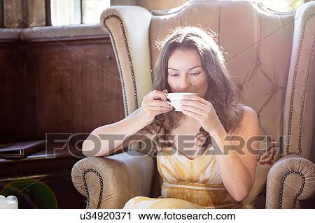 Woman drinking cup of tea in old armchair at Thornbury Castle, South Gloucestershire, UK View Large Photo Image Stock Image - Woman drinking cup of tea in old armchair at Thornbury Castle, South Gloucestershire, UK. Fotosearch