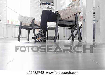 Woman sitting in chair in kitchen, low section View Large Photo Image Stock Image - Woman sitting in chair in kitchen, low section. Fotosearch