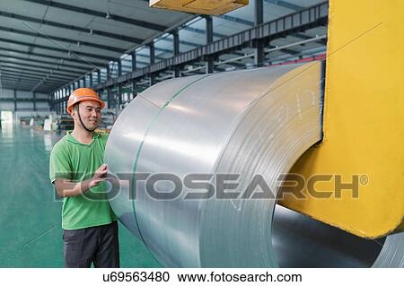 Stock Image - Worker in solar panel assembly factory, Solar Valley, Dezhou, China. Fotosearch