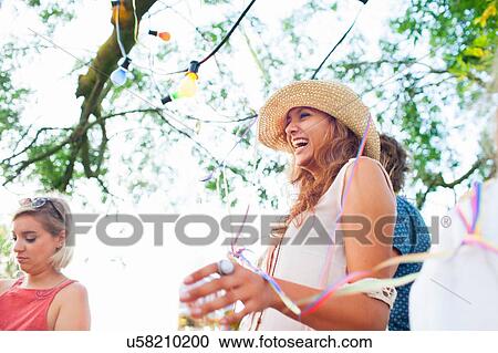 Young adult friends wrapped in streamers at sunset party in park View Large Photo Image Stock Image - Young adult friends wrapped in streamers at sunset party in park. Fotosearch