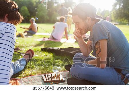 Young adults playing board game at sunset party in park View Large Photo Image Stock Image - Young adults playing board game at sunset party in park. Fotosearch