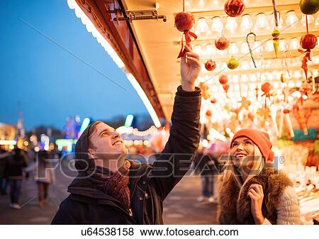 Stock Photo - Young couple choosing baubles at xmas festival in Hyde Park, London, UK. Fotosearch