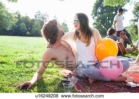 Stock Photo - Young couple flirting at park party. Fotosearch