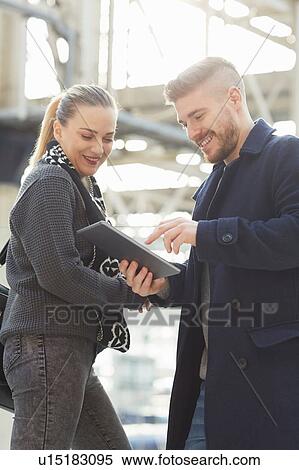 Young couple looking at digital tablet, outdoors View Large Photo Image Stock Photography - Young couple looking at digital tablet, outdoors. Fotosearch
