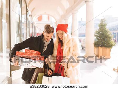 Young couple looking at xmas gifts in Covent Garden, London, UK View Large Photo Image Stock Photo - Young couple looking at xmas gifts in Covent Garden, London, UK. Fotosearch