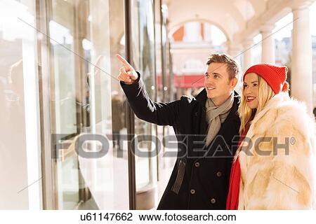 Stock Image - Young couple window shopping in Covent Garden, London, UK. Fotosearch