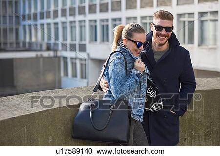 Young couple, young man's arm around young woman, outdoors View Large Photo Image Stock Image - Young couple, young man's arm around young woman, outdoors. Fotosearch