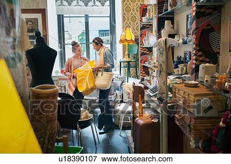 Young female customer looking at yellow blanket in vintage shop View Large Photo Image Stock Photo - Young female customer looking at yellow blanket in vintage shop. Fotosearch