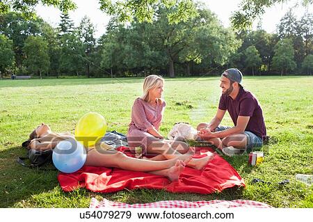 Young man and woman chatting on picnic blanket at park party View Large Photo Image Stock Photo - Young man and woman chatting on picnic blanket at park party. Fotosearch