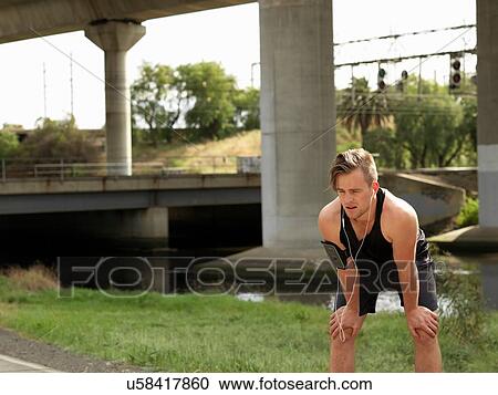 Young man beside river, taking a break from exercise View Large Photo Image Stock Image - Young man beside river, taking a break from exercise. Fotosearch