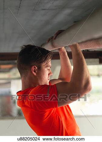 Young man doing pull ups under bridge View Large Photo Image Picture - Young man doing pull ups under bridge. Fotosearch