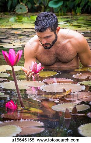 Young man waist deep in water among lily pads looking down, Taiba, Ceara, Brazil View Large Photo Image Stock Photography - Young man waist deep in water among lily pads looking down, Taiba, Ceara, Brazil. Fotosearch