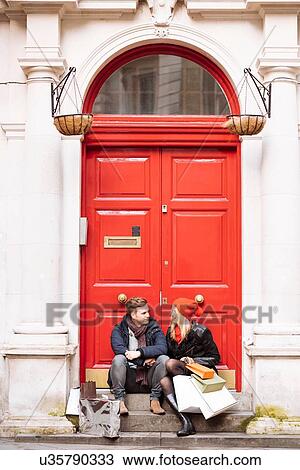Young shopping couple taking a break on doorstep, London, UK View Large Photo Image Stock Image - Young shopping couple taking a break on doorstep, London, UK. Fotosearch