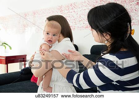 Young woman and baby daughter with grandmother on sofa View Large Photo Image Stock Photo - Young woman and baby daughter with grandmother on sofa. Fotosearch