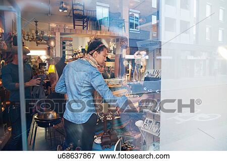 Young woman browsing old photographs in vintage shop View Large Photo Image Stock Photo - Young woman browsing old photographs in vintage shop. Fotosearch