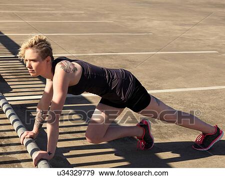 Young woman doing push up training in urban parking lot View Large Photo Image Stock Photo - Young woman doing push up training in urban parking lot. Fotosearch