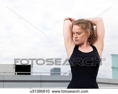 Young woman doing warm up training in parking lot View Large Photo Image Stock Image - Young woman doing warm up training in parking lot. Fotosearch