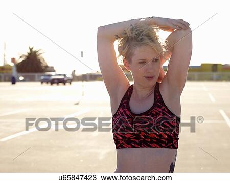 Young woman doing warm up training in parking lot View Large Photo Image Stock Image - Young woman doing warm up training in parking lot. Fotosearch