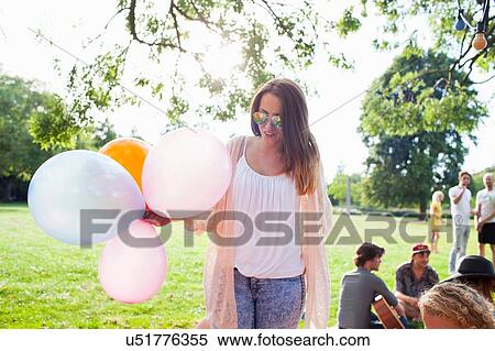 Young woman with bunch of balloons at park party View Large Photo Image Stock Photography - Young woman with bunch of balloons at park party. Fotosearch