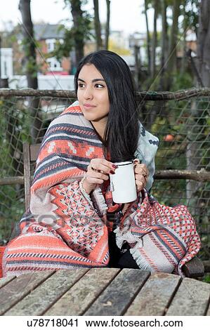 Young woman wrapped in blanket having coffee, Hampstead Heath, London View Large Photo Image Stock Image - Young woman wrapped in blanket having coffee, Hampstead Heath, London. Fotosearch