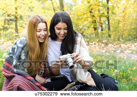 Stock Photo - Young women smiling at camera in forest, Hampstead Heath, London. Fotosearch