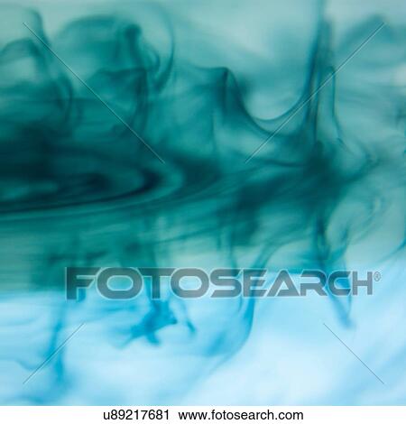 Stock Image - Abstract of blue and turquoise ink dispersing in water. Fotosearch