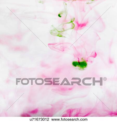 Stock Image - Abstract of pink and green ink dispersing in water. Fotosearch
