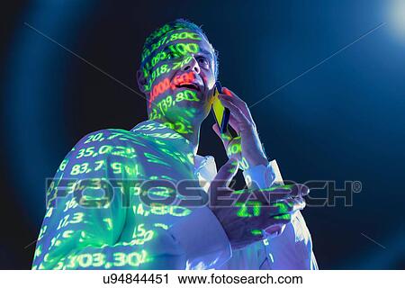 Businessman using mobile phone with projected financial data View Large Photo Image Stock Image - Businessman using mobile phone with projected financial data. Fotosearch