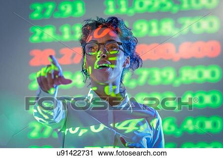 Stock Image - Businesswoman making presentation with graphical financial data projection. Fotosearch