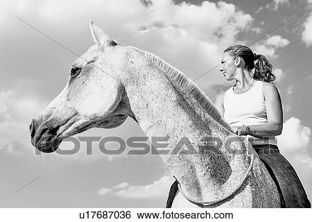B&W portrait of woman riding grey horse against sky View Large Photo Image Stock Photograph - B&W portrait of woman riding grey horse against sky. Fotosearch