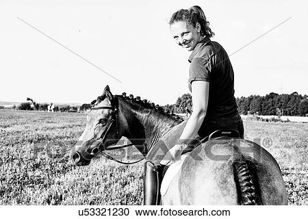 B&W portrait of woman riding horse in field and looking over her shoulder View Large Photo Image Stock Image - B&W portrait of woman riding horse in field and looking over her shoulder. Fotosearch