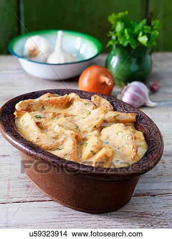 Picture - Casserole dish with turkey casserole, garlic, onion and green herbs. Fotosearch