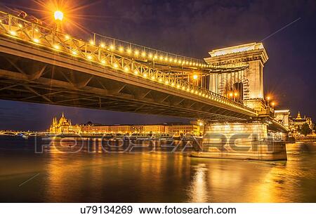 Stock Photo - Chain Bridge illuminated at night on the Danube, Hungary, Budapest. Fotosearch
