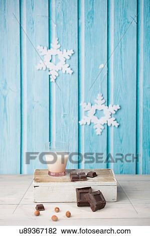 Chocolate cubes, hazelnuts, glass of milk, paper snowflakes on blue wall View Large Photo Image Stock Image - Chocolate cubes, hazelnuts, glass of milk, paper snowflakes on blue wall. Fotosearch