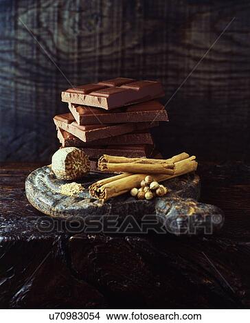 Cinnamon stick, nutmeg and broken chocolate bars stacked on wooden cutting board View Large Photo Image Picture - Cinnamon stick, nutmeg and broken chocolate bars stacked on wooden cutting board. Fotosearch