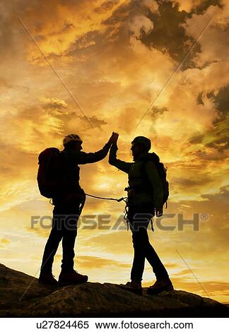 Stock Photography - Climbers exulting on mountain top at sunset, Mont Blanc, France. Fotosearch