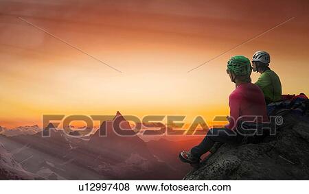 Stock Photo - Climbers on mountain top watching sunset over Matterhorn, Mont Blanc, France. Fotosearch