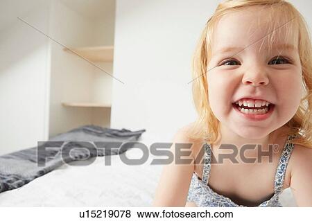 Close up of female toddler playing on bed View Large Photo Image Stock Photo - Close up of female toddler playing on bed. Fotosearch